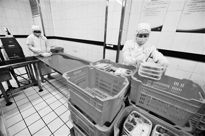 工作人員正將做好的盒飯裝車